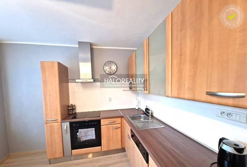 Küche in einer 3-Zimmer-Wohnung mit Holzschränken und versilberten Geräten.