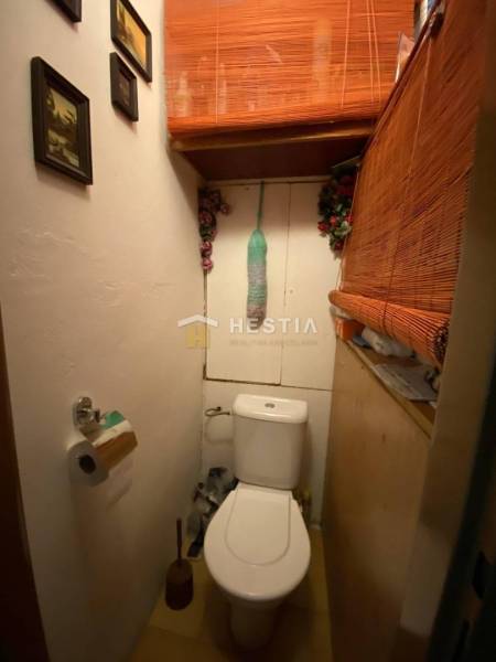 Kleines Badezimmer in einer 2-Zimmer-Wohnung mit dekorativen Bambuselementen und Bildern an der Wand.