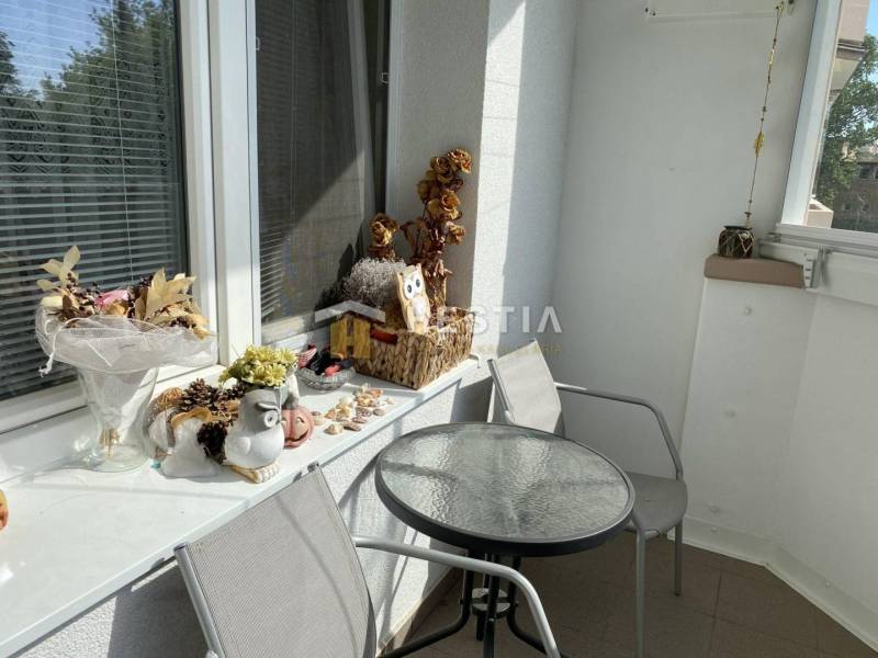 Ein Balkon mit Dekorationen und einem Tisch in einer 2-Zimmer-Wohnung bietet eine angenehme Sitzgelegenheit.