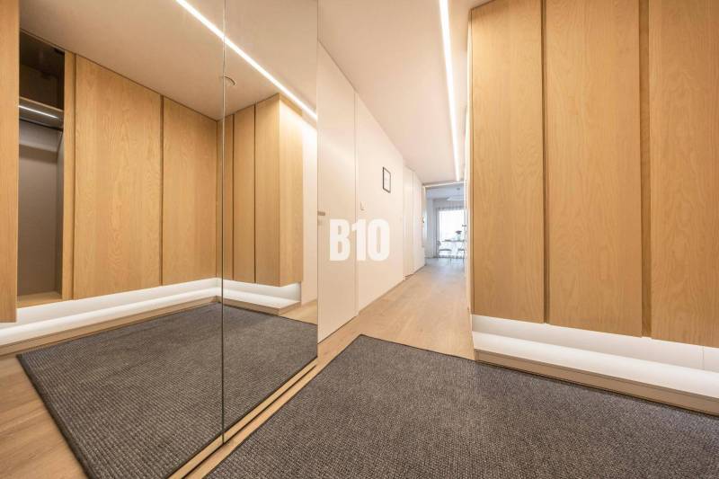 Flur in einer 3-Zimmer-Wohnung mit Holzboden und Spiegel.