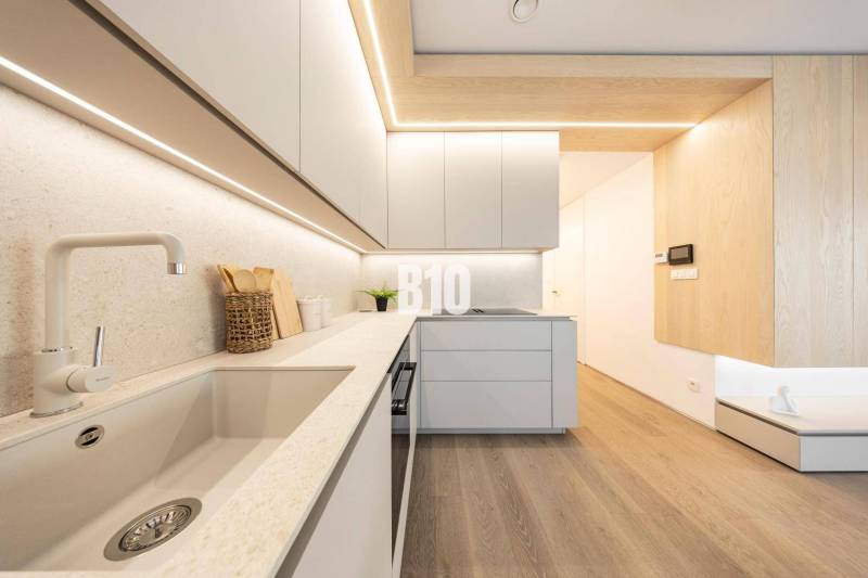 Küche in einer 3-Zimmer-Wohnung mit Holzboden und minimalistischem Design.