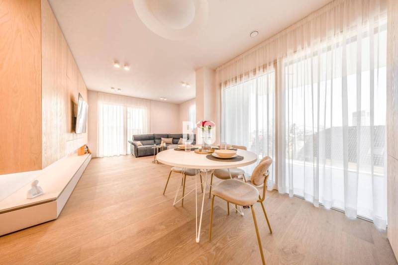 Wohnzimmer in einer 3-Zimmer-Wohnung mit Holzboden, Esstisch und Sofa.
