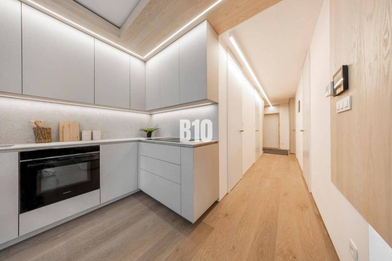 Küche in einer 3-Zimmer-Wohnung mit Holzboden und hellen Möbeln.