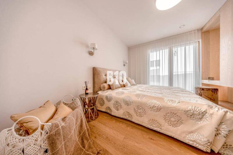 Schlafzimmer in einer 3-Zimmer-Wohnung mit einem Bett und einem Boden in Holzoptik.