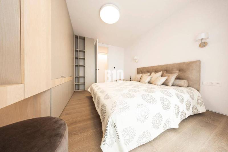 Helles Schlafzimmer mit Holzboden und Einbauschränken in einer 3-Zimmer-Wohnung.
