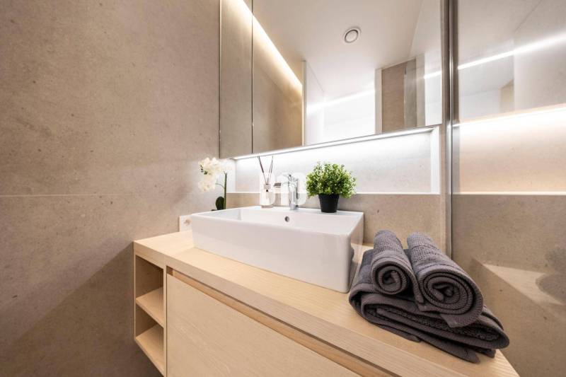 Badezimmer mit modernem Waschbecken, Handtüchern und Dekoration in einer 3-Zimmer-Wohnung.