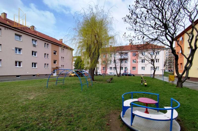 Spielplatz mit Klettergerüsten und Bäumen in der Mierová-Straße in Sabinov, vor einer 2-Zimmer-Wohnung.