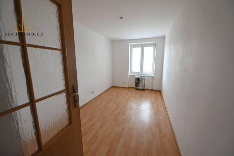 Ein Zimmer mit Holzboden in einer 2-Zimmer-Wohnung, ein heller Raum.