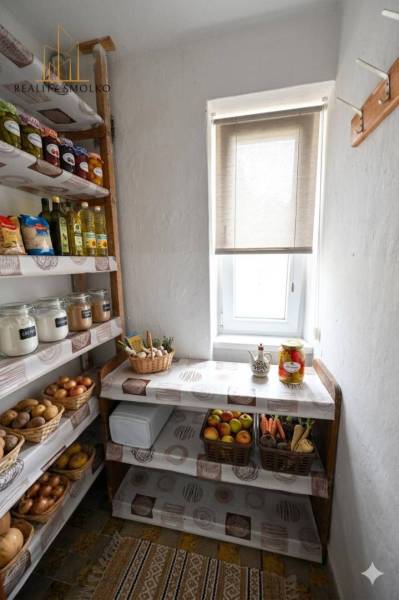 Speisekammer mit Regalen, Obst, Gemüse und Lebensmitteln in einer 2-Zimmer-Wohnung, Licht fällt durch das Fenster.