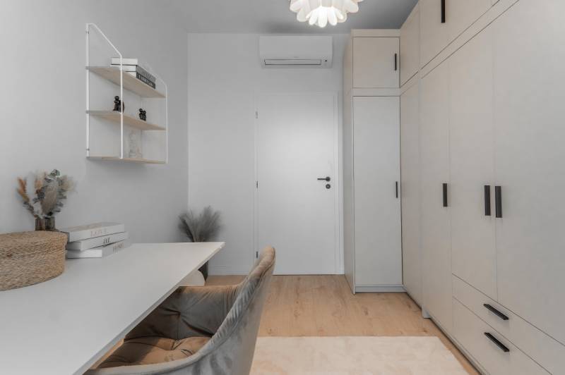 Arbeitszimmer in einer 3-Zimmer-Wohnung mit Stauraum, Tisch und dekorativen Elementen.