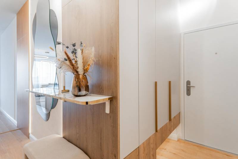 Eingangsflur mit Spiegel, Schrank und Dekoration in einer 3-Zimmer-Wohnung mit Holzboden.