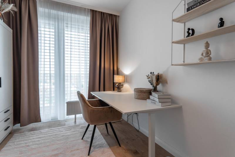 Arbeitsbereich mit Schreibtisch, bequemem Sessel und Regal in einer 3-Zimmer-Wohnung.