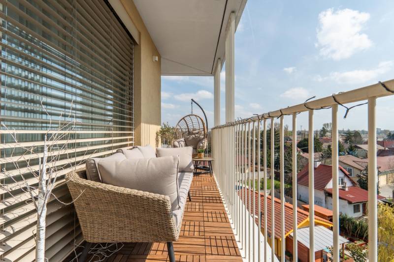 Balkon einer 3-Zimmer-Wohnung in Bratislava - Ružinov mit Außensitzbereich und Holzdekor.