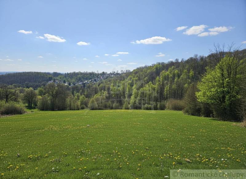 Frühlingslandschaft in der Umgebung von Krupina, Grundstücke - Wohnen, grüne Wiesen und Wälder am Horizont.