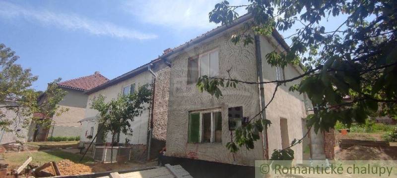 Ein Einfamilienhaus in Šiatorská Bukovinka, umgeben von Grün und Bäumen, mit einem schrägen Dach.