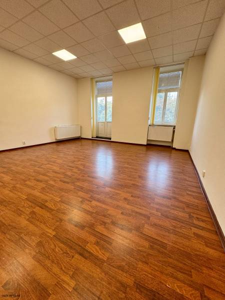 Büros mit Holzboden, heller Innenraum mit großen Fenstern.