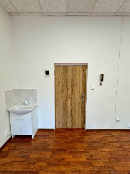 Boden mit Holzdekor, Waschbecken, Türen und Deckenplatten im Büro.