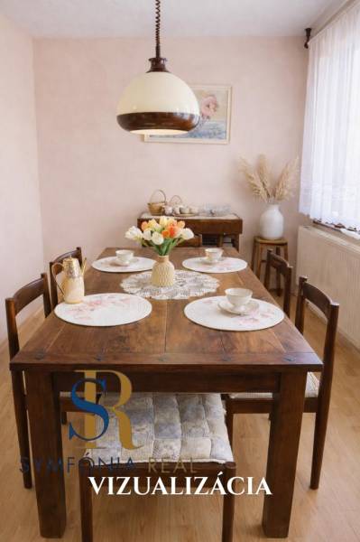 Esszimmer eines Einfamilienhauses mit einem Holztisch, dekoriert mit Blumen und Porzellan.