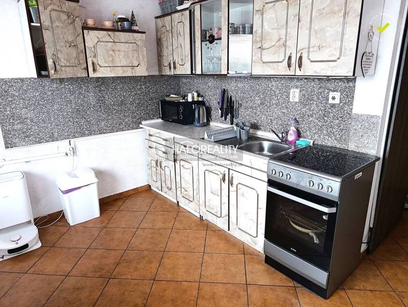 Küche mit Fliesen und Küchenzeile in einer 2-Zimmer-Wohnung.