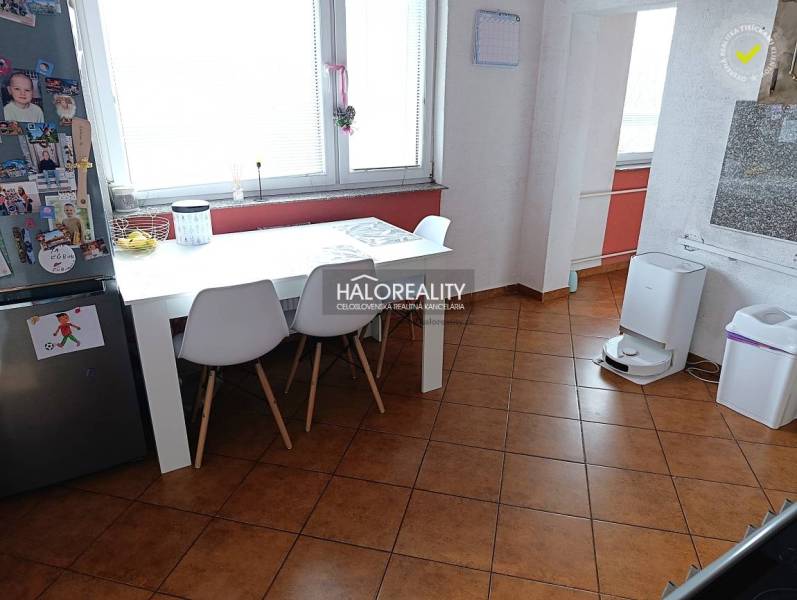 Esszimmer in einer 2-Zimmer-Wohnung mit weißem Tisch und braunem Boden.