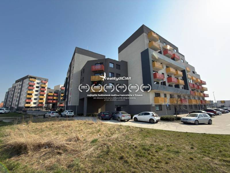 Wohnhäuser in der Mikovíniho-Straße in Trnava mit Parkplatz und Grünfläche.