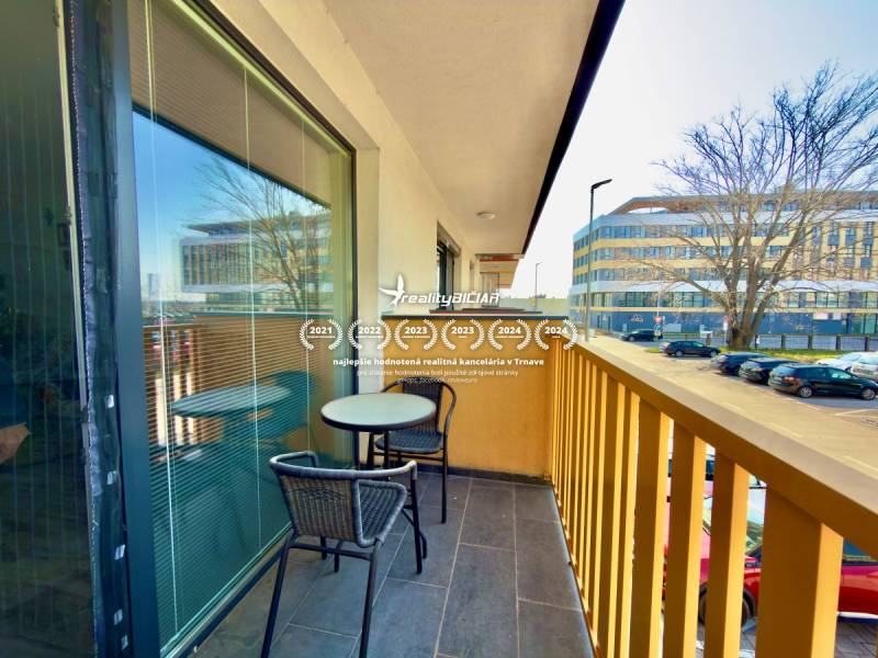 Der Balkon einer 2-Zimmer-Wohnung in der Mikovíniho-Straße in Trnava mit Sitzgelegenheit und Blick auf die Straße.