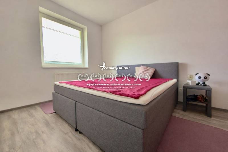 Schlafzimmer in einer 2-Zimmer-Wohnung mit Bett, Holzboden und Nachttisch.