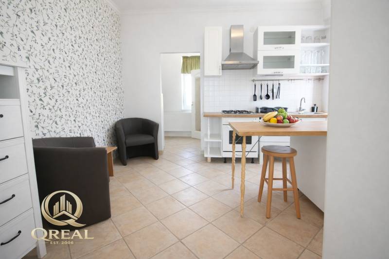 Küche mit Bartresen, Obst und Sesseln in einer Einzimmerwohnung.