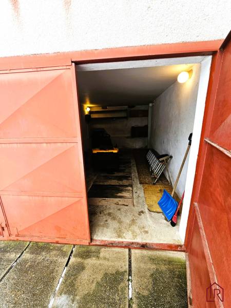 Eine Garage in einem Einfamilienhaus in Kameňany mit offenen Metalltüren und Werkzeugen.