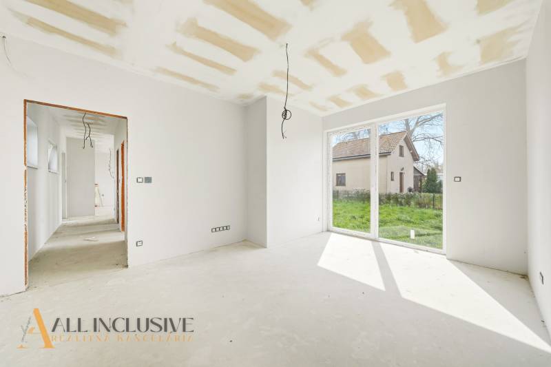 Helles Zimmer in der Hütte mit großen Fenstern und Blick in den Garten.