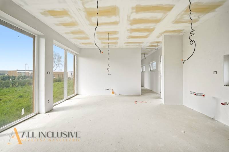 Ein geräumiges Ferienhaus mit weißen Wänden und großen Fenstern, einem Boden in Holzoptik.