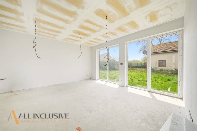 Das Innere der Hütte mit großen Fenstern und Blick auf den grünen Garten.