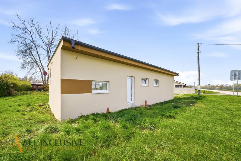 Ein Ferienhaus in der Gemeinde Vojka nad Dunajom, umgeben von einer Rasenfläche.