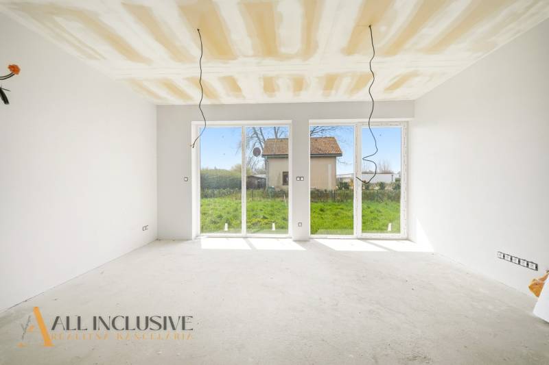 Ein geräumiger Raum in einer Hütte mit großen Fenstern und Blick auf den Garten.