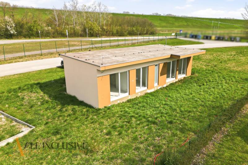Eine Hütte in Vojka nad Dunajom auf einem grasbewachsenen Grundstück mit einer Straße im Hintergrund.