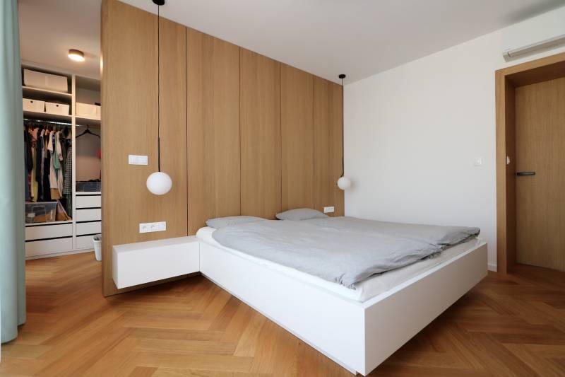 Schlafzimmer in einer 4-Zimmer-Wohnung mit Bett, Holzboden und Kleiderschrank.
