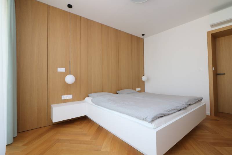 Schlafzimmer mit Hängeleuchten und Holzboden in einer 4-Zimmer-Wohnung.