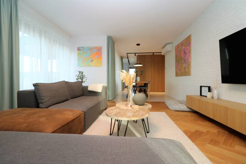 Stilvolles Wohnzimmer in einer 4-Zimmer-Wohnung mit Holzboden und Kunstgemälden.