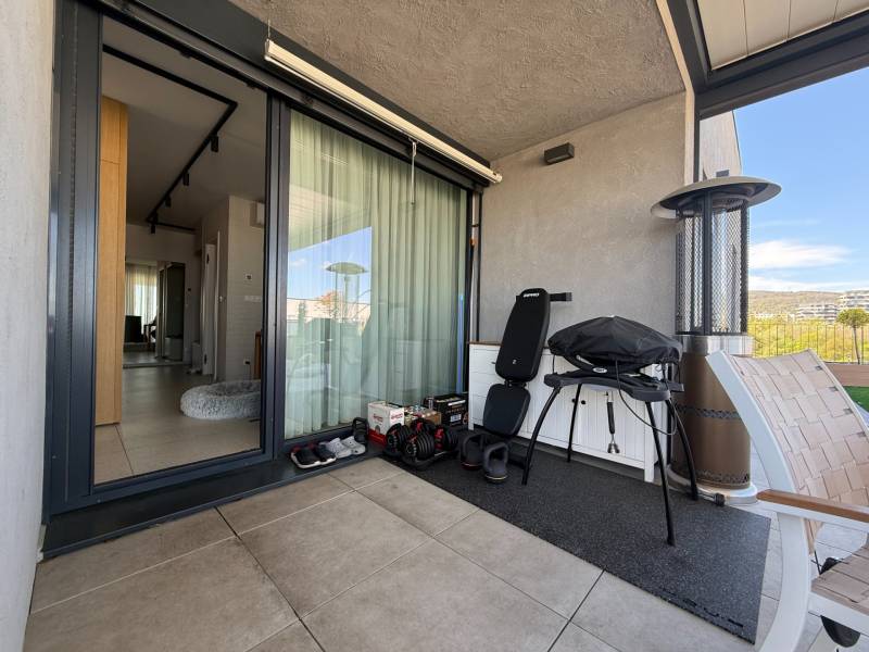 Balkon einer 4-Zimmer-Wohnung mit Grill, Stuhl und Blick auf Dúbravka.