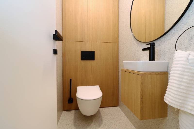 Toilette mit Holzboden und modernem Waschbecken in einer 4-Zimmer-Wohnung.