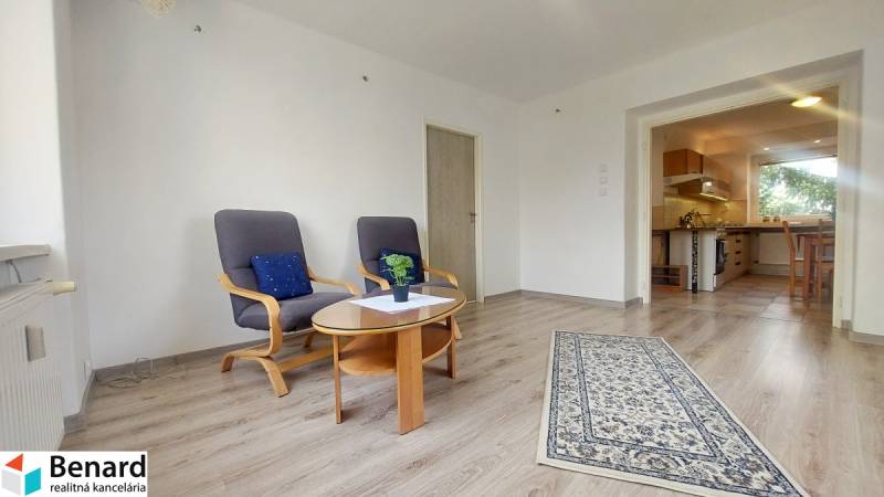 Wohnzimmer in einer 2-Zimmer-Wohnung mit Holzboden und bequemen Sesseln.