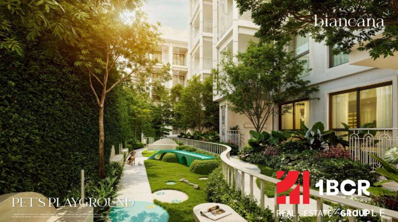 Außenbereich eines Wohnbaus in Phuket mit einem von Grün umgebenen Kinderspielplatz.