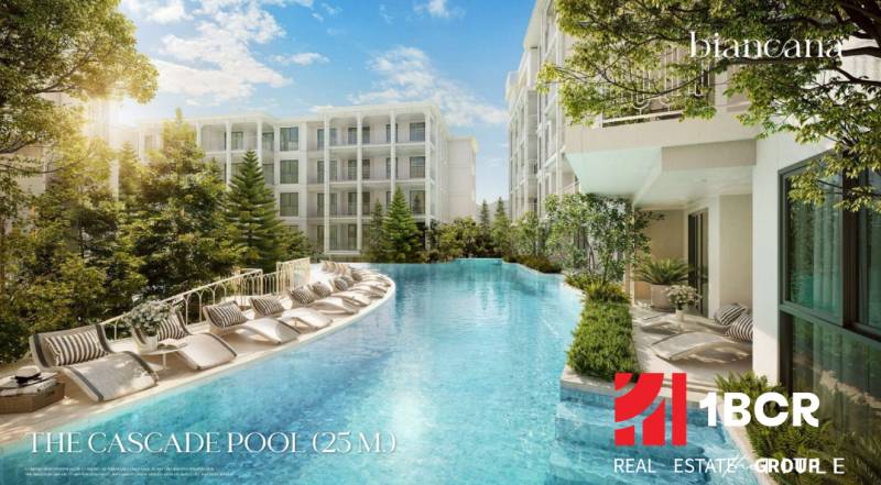 Ein Pool mit Liegestühlen, umgeben von im Bau befindlichen Wohngebäuden in Phuket.