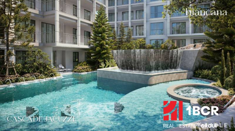 Ein Pool und ein Whirlpool, umgeben von Grünflächen, beim Bau von Wohnungen in Phuket.