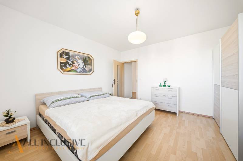 Schlafzimmer mit Holzboden in einem Einfamilienhaus und einem Bild an der Wand.