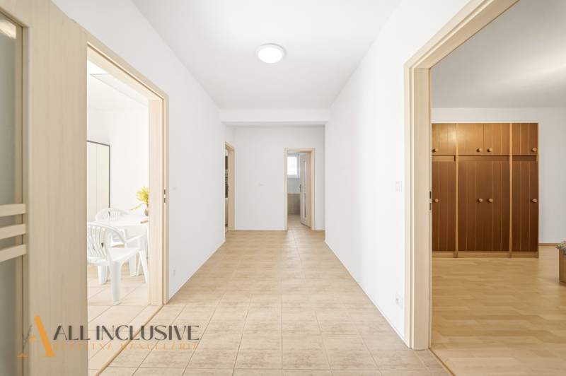 Der Flur in einem Einfamilienhaus mit Türen zu den Zimmern und Fliesen auf dem Boden.