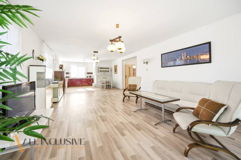 Wohnzimmer in einem Einfamilienhaus mit Holzboden und hellen Möbeln.