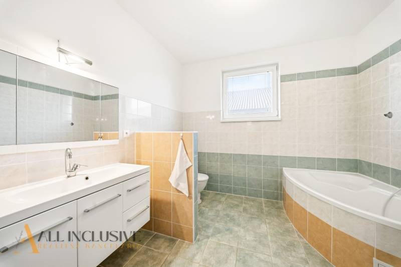 Kúpeľňa s vaňou, zrkadlom a úložným priestorom v rodinnom dome.

Badezimmer mit Badewanne, Spiegel und Stauraum in einem Einfamilienhaus.