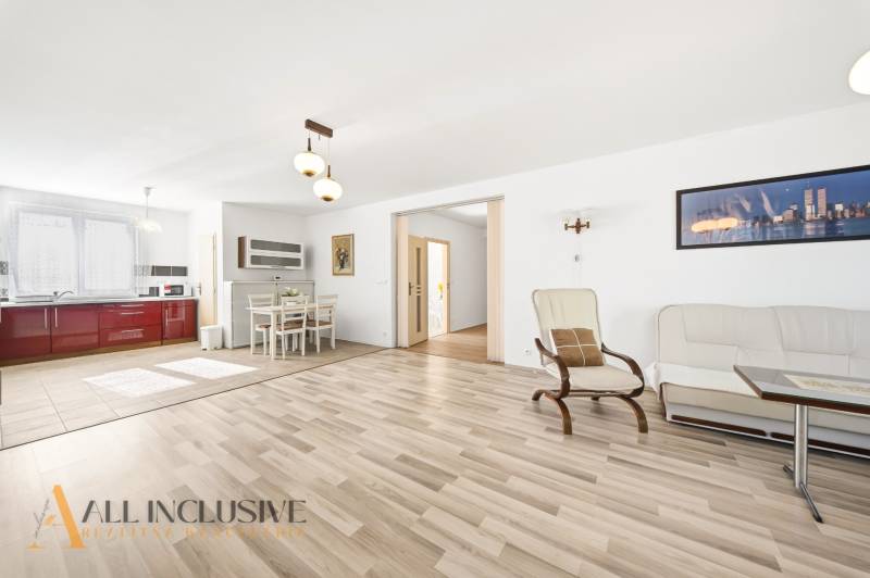 Helles Wohnzimmer mit Küche, Boden mit Holzdekor, Essbereich.