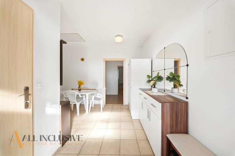 Innenraum eines Einfamilienhauses mit einem weißen Tisch und Stühlen, mit einem großen Spiegel an der Wand.